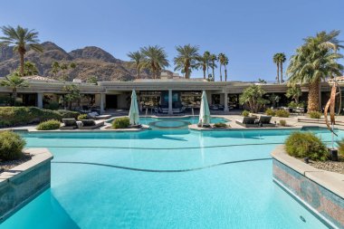Güzel bir açık havuz, jakuzi ve dinlenme odası manzarası. Dağ zeni ve palmiye ağaçları. Indian Wells, California 'da büyük bir konut arazisinde..