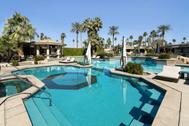 Çok güzel bir açık havuz, jakuzi ve dinlenme odası manzarası. Indian Wells, California 'da büyük lüks bir arazide çardak var..