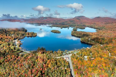 Adirondack Eyalet Parkı 'ndaki Mavi Dağ Gölü' nün havadan görünüşü. New York 'un kuzeyinde sonbaharın en yüksek döneminde alçak asılı bulutlar..