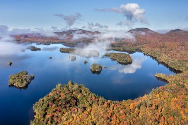 Adirondack Eyalet Parkı 'ndaki Mavi Dağ Gölü' nün havadan görünüşü. New York 'un kuzeyinde sonbaharın en yüksek döneminde alçak asılı bulutlar..