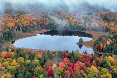 Tom Peck Pond, New York, Adirondack Park 'ta, New York' ta sis ve bulutların arasından görülüyor..
