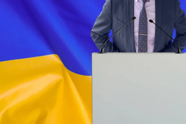 关于乌克兰国旗背景的带话筒和穿着西服的论坛报 商人和部落关于乌克兰国旗背景的报道 领奖台上拿着麦克风的政客 背景是乌克兰国旗 — 图库照片