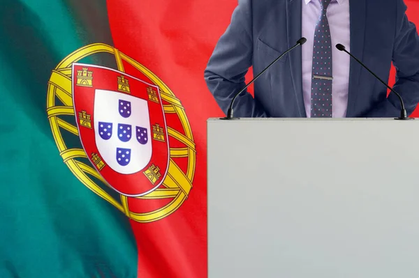 在葡萄牙国旗背景上有话筒和穿着西服的男人的论坛报 葡萄牙国旗背景上的商人和部落客 领奖台上的政客 手持麦克风背景的葡萄牙国旗 — 图库照片