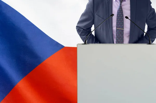 チェコ共和国の国旗を背景にマイクとビジネスマンとのトリビューン マイクを背景にした表彰台の政治家チェコ共和国国旗 — ストック写真