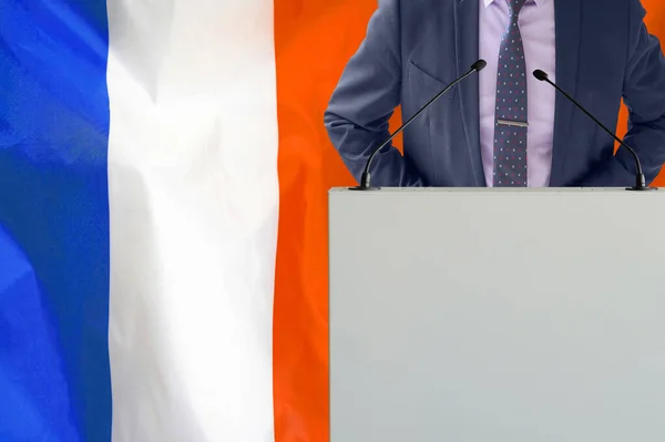带着话筒和穿着西服的论坛报在法国国旗的背景上 在法国国旗背景上的商人和领班 领奖台上拿着麦克风的政客 背景是法国国旗 — 图库照片