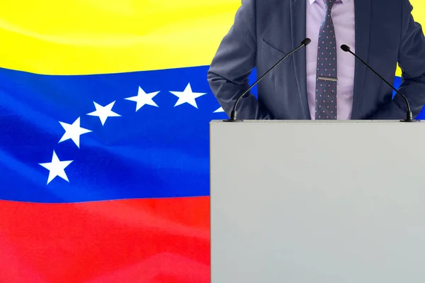 关于委内瑞拉国旗背景的带话筒和穿着西服的论坛报 在委内瑞拉国旗背景上的商人和部落客 领奖台上的政客 手持麦克风背景的委内瑞拉国旗 — 图库照片