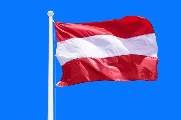 Austria flag waving against clean blue sky, close up. Austria flag in the blue sky. Flag Austria on blue sky background