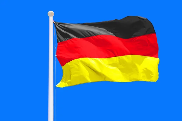 Germany flag waving against clean blue sky, close up. Germany flag in the blue sky. Flag Germany on blue sky background