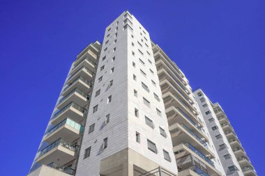 Modern bir ev, şehirde mavi gökyüzü arka planında yeni bir apartman. İsrail 'deki Konut Binası. Gayrimenkul konsepti ve yeni daire