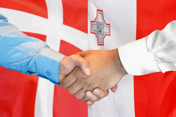 在两面旗帜的背景下进行商业握手 男人们在丹麦国旗和马耳他国旗的背景下握手 支助概念 — 图库照片