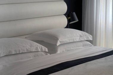 Yumuşak yastıklı bir otel odasında boş bir yatak. Turizm ve tatil kavramı