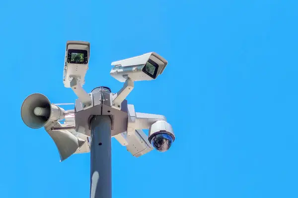 青い空の背景にセキュリティカメラ スピーカー 青空の背景に空気警報 — ストック写真