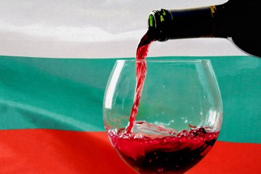 Bulgaristan bayrağının arka planında kırmızı şarap şişeden bardağa doluyor. Bulgaristan 'da şarap ve şarap ihracatı kavramı