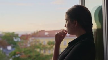 Genç bir kadının yüzüne yaklaş. Ağla ve pencerenin önünde üzgün bir an geçir. Hüzünlü ya da kötü anıları olan bir kadın. Düşünceli ve melankolik. Geçmiş olayları hatırlamak ya da bir şey beklemek.