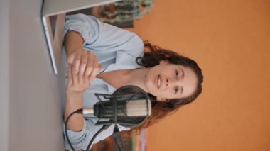 Dikey video - genç bir kadın video konuşmasında kameraya açıklama yapıyor. Konuşan ve dinleyen bir video bloğunda konferans çağrısı ya da içerik oluşturucu. Bir podcast sunuyor ya da röportaj yapıyor.