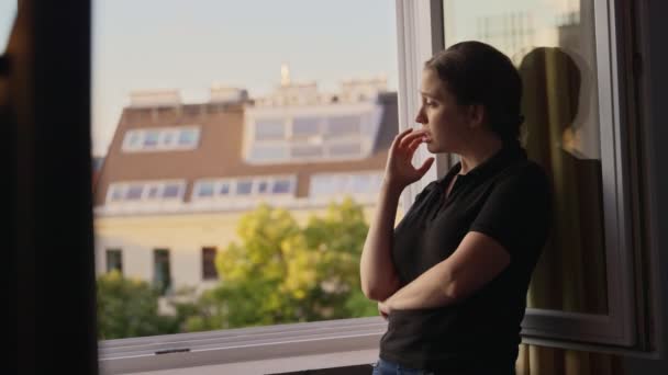 Νεαρή Γυναίκα Στέκεται Στο Παράθυρο Έχοντας Μια Θλιβερή Σκληρή Στιγμή — Αρχείο Βίντεο