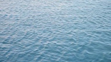 Yavaş hareket eden mavi deniz ya da dalgalarla rüzgarda hareket eden okyanus suyu. Okyanustaki ya da limandaki huzurlu sular. Tuzlu ya da tatlı suyun en üst görüntüsü.