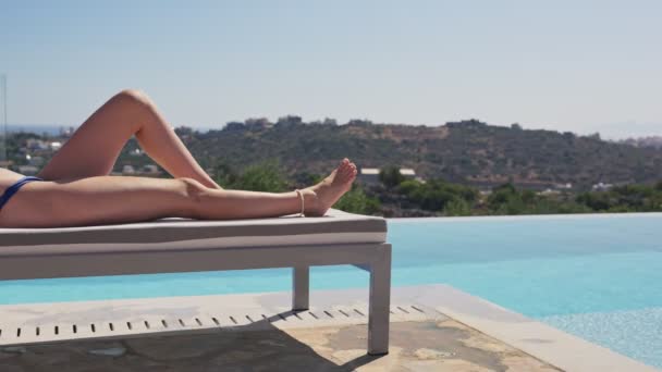 豪華なプールとスパで太陽の下でリラックスした休日の若い女性日光浴 緑の丘や海を眺めながら ホテルやスイートでリラックスした日焼けを楽しむ女性観光客や世界の旅行者 — ストック動画