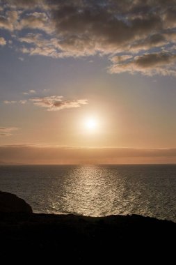 Fuerteventura 'nın batı kıyısındaki altın saat, gün batımının güzel akşam ışığında açık deniz üzerindeki manzarası.