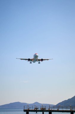 Uçak karaya çıkmak için suya yaklaşıyor, dik bir görüntü.