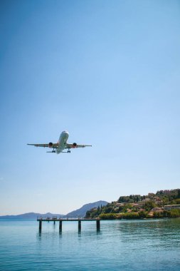 Corfu kasabasına yaklaşan bir uçak, denizin güzel mavi sularına yakın.