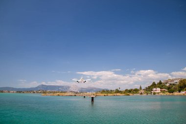 Bir uçağın Corfu havaalanına inişi, güzel bir panoramik dağ ve deniz manzarası, arkadan çekilmiş bir fotoğraf, Yunanistan