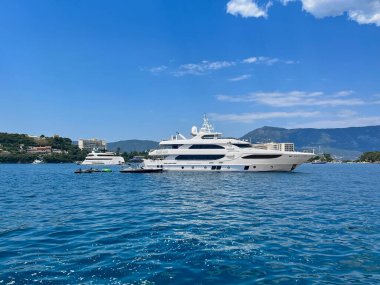 Yunanistan 'ın Korfu adasının mavi sularında büyük beyaz bir yat ve jet ski.