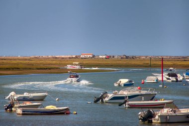 Portekiz 'in Faro kıyısındaki Ria Formosa Ulusal Parkı' ndaki Algarve 'de bulunan bir gölde bir sürü motorlu tekne.