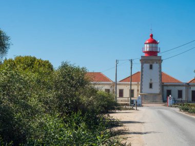 Tipik kırmızı ve beyaz Portekiz tarihi deniz feneri Cabo Sardao binası Ponta do Cavaleiro, Rota Vicentina sahili, Odemira bölgesi, Portekiz