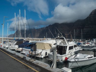 Los Gigantes, Tenerife, Kanarya Adaları, 18 Aralık 2021, Los Gigantes Limanı 'nda tekneleri ve yatları olan liman. Arka planda Los Gigantes 'in rıhtım ve liman manzarası var..