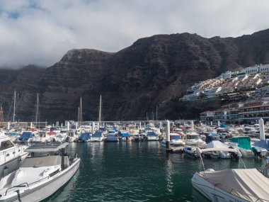 Los Gigantes, Tenerife, Kanarya Adaları, 18 Aralık 2021, Los Gigantes Limanı 'nda tekneleri ve yatları olan liman. Arka planda Los Gigantes 'in rıhtım ve liman manzarası var..