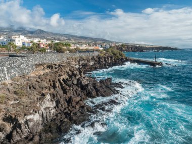 Geleneksel mimarisi ile Guya de Isora belediyesinin bir parçası olan Alcala köyü manzarası ve küçük iskeleli keskin lav kaya kıyıları. Tenerife, Kanarya Adaları, İspanya.