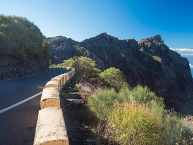 İspanya 'nın Kanarya Adaları' ndaki Tenerife bölgesinde bulunan Masca köyüne doğru kıvrımlı kıvrımlı dağ yolu ile çarpıcı yemyeşil bir manzara. Güneşli kış günü, mavi gökyüzü.