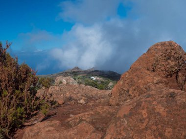 Canlı kırmızı volkanik kayalar ile Teno dağ sırası, Tenerife, Kanarya Adaları, İspanya ve Avrupa 'daki dik bir uçurum boyunca yürüme yolu arasındaki patika. Güneşli kış günü.