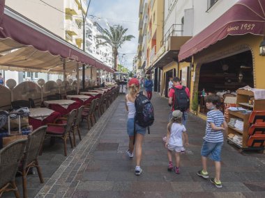 Los Cristianos, Tenerife, Canary Islands, Spain, december 26, 2021: Streets with tourist shops, restaurants and walking people. Los Cristianos is popular resorts in the Tenerife. Sunny christmas day