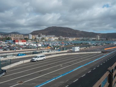 Los Cristianos, Tenerife, Canary Islands, Spain, december 26, 2021: Panoramic view of Los Cristianos from central parking at the port with city building, hotels, apartments and bare hills in distance.