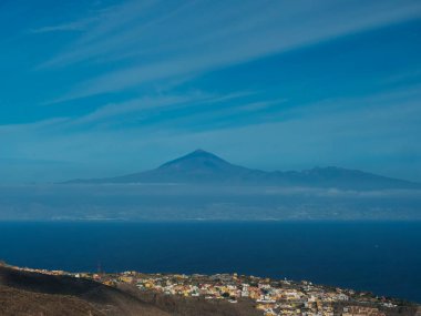 San Sebastian de la Gomera manzarası, Tenerife adasında Teide Yanardağı ve arka planda Atlantik Okyanusu ile şehrin silueti. La Gomera, Kanarya Adaları, İspanya. Mavi gökyüzü, boşluğu kopyala.