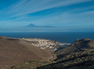 San Sebastian de la Gomera manzarası, Tenerife adasında Teide Yanardağı ve arka planda Atlantik Okyanusu ile şehrin silueti. La Gomera, Kanarya Adaları, İspanya. Mavi gökyüzü, boşluğu kopyala.