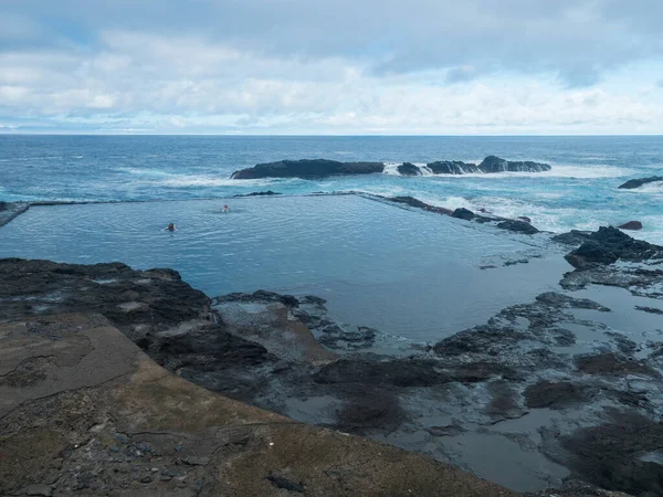 Hermigua, La Gomera, Kanarya Adaları, İspanya, 27 Aralık 2021: Pescante de Hermigua 'daki doğal deniz havuzu, limanın beton sütunları ve kalıntıları, okyanus kıyısındaki muz ihracatı için eski yükleme istasyonu