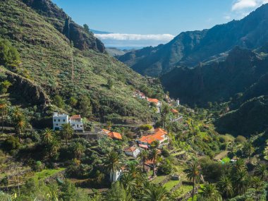 Küçük bir köy olan La Laja 'yı, yemyeşil vadideki palmiyeli kırmızı ve beyaz kırsal evleri görebilirsiniz. La Gomera 'daki Garajonay Ulusal Parkı yakınlarındaki manzara, Kanarya Adaları, İspanya