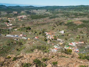 Fortaleza Dağı 'nın zirvesinden görülen Chipude köyündeki hava manzarası. Beyaz bulutlar ve La Palma adası yukarıda, mavi gökyüzü. La Gomera, Kanarya Adaları, İspanya