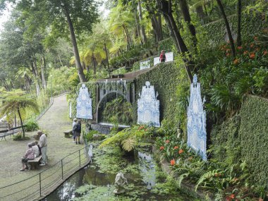 Funchal, Madeira, Portekiz, 19 Mayıs 2022: Monte sarayı tropikal bahçesi manzarası. Funchal şehrinin yukarısındaki Botanik Bahçesinde çiçekler, ağaçlar, heykeller, mimari ve su elementleri.