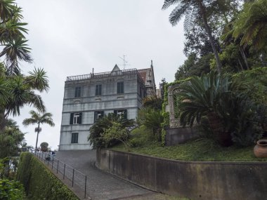 Funchal, Madeira, Portekiz, 19 Mayıs 2022: Monte sarayı tropikal bahçesi manzarası. Funchal şehrinin yukarısındaki Botanik Bahçesinde çiçekler, ağaçlar, heykeller, mimari ve su elementleri.