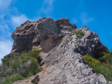 Pico Grande 'nin kayalık tepesi Madeira' nın mavi gökyüzündeki en yüksek zirvelerinden biri. PR12, Madeira, Portekiz dağ manzarası.