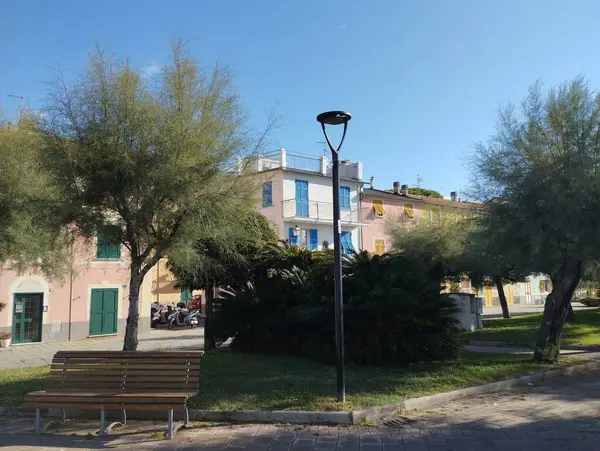 stock image Riva Trigoso, Sestri Levante, Liguria, Italy, September 21, 2023: view of pedestrian promenade in Riva Trigoso village with street lamp, bench and trees at sunny day.
