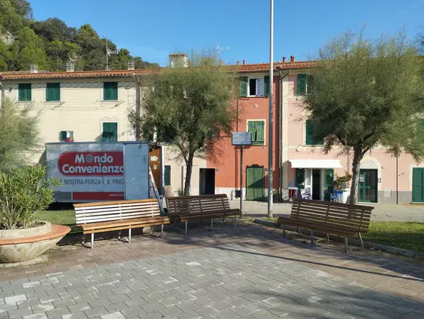 stock image Riva Trigoso, Sestri Levante, Liguria, Italy, September 21, 2023: view of pedestrian promenade in Riva Trigoso village with small square, bench and trees at sunny day.