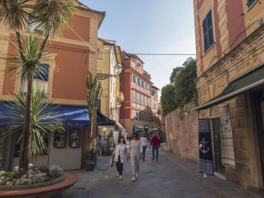 Sestri Levante, Liguria, İtalya, 23 Eylül 2023: Renkli binalar, dükkanlar, restoranlar ve yürüyen turistlerle eski balıkçı köyünün merkezindeki Paved gezinti alanı sokak manzarası. Unesco sitesi.