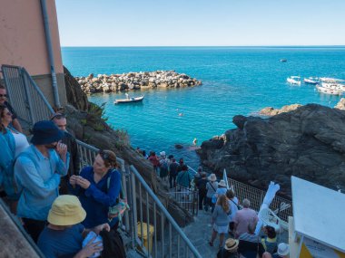 Manarola, Liguria, İtalya, 25 Eylül 2023: Balıkçı tekneleriyle Manarola 'nın eski limanının manzarası ve turistlerle dolu basamakları. National Park Cinque Terre 'deki tipik geleneksel köy.