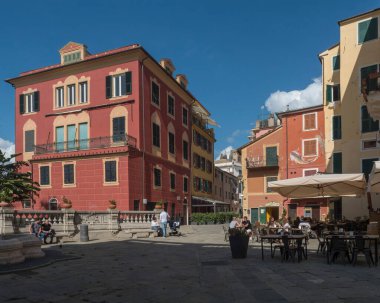Sestri Levante, Liguria, İtalya, 23 Eylül 2023: Renkli binalar, dükkanlar, restoranlar ve yürüyen turistlerle eski balıkçı köyünün merkezindeki Paved gezinti alanı sokak manzarası. Unesco sitesi.