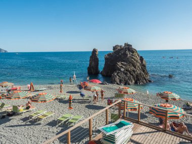 Monterosso al Mare, Ulusal Park Cinque Terre, Liguria, İtalya, 25 Eylül 2023: Güneşli bir günde kaya oluşumu ve güneşlenen turist ve ligurian Denizi manzarası.